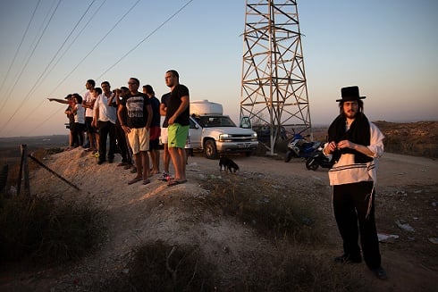 Israeli stand on a hill overlooking the Gaza Strip yesterday, to watch the fighting between the Israeli army and Palestinian militants. (Photo: Menahem Kahana/AFP/Getty Images)
