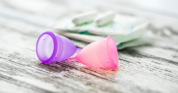 Different types of feminine hygiene products - menstrual cups, sanitary pads and tampons. Selective focus and shallow DOF