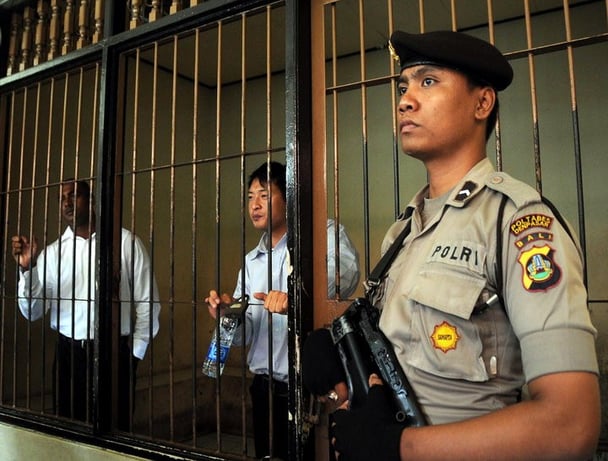 An Indonesian policeman stands guard next to a detention room where Australians Myuran Sukumaran (L) and Andrew Chan (C), members of the so called Bali Nine gang, wait for their trial in Denpasar on the island of Bali on October 8, 2010. An Indonesian prison chief testified on October 8, that two Australian drug smugglers on death row have given great contribution in teaching fellow inmates and should not be executed. Andrew Chan and Myuran Sukumaran, members of the so-called Bali Nine gang, are seeking 20 years to life in prison for a 2005 attempt to smuggle 8.3 kilograms (18 pounds five ounces) of heroin into Australia from Bali island. AFP PHOTO / SONNY TUMBELAKA (Photo credit should read SONNY TUMBELAKA/AFP/Getty Images)