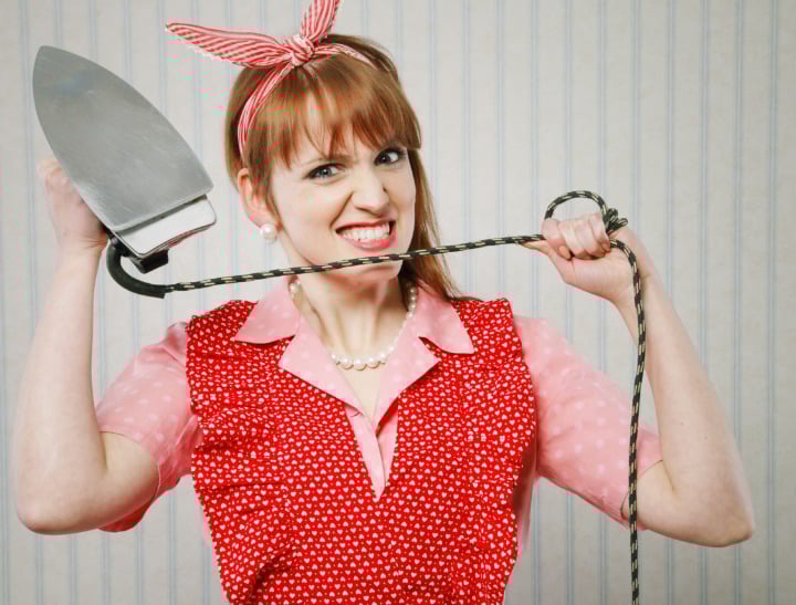 Stressed young woman housewife with iron