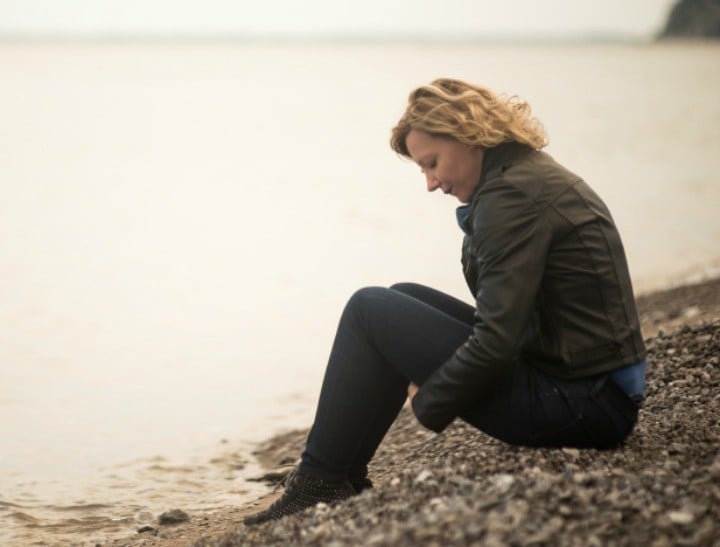 Pensive/dreaming woman on the beach