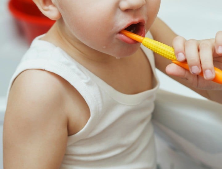 little boy learns to brush teeth with toothbrush