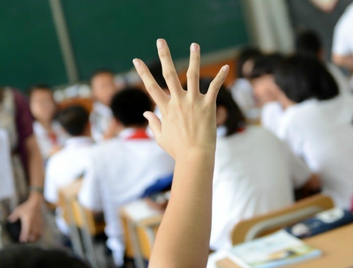 Raised hands in class of middle school.
