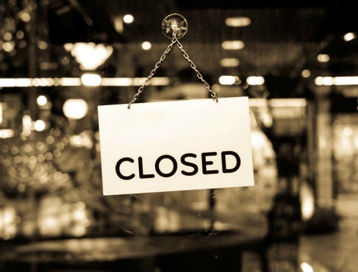 A closed sign hanging in a shop window