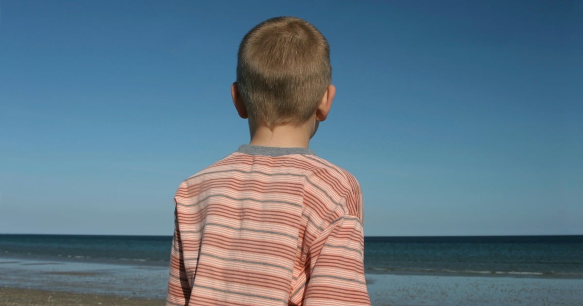 boy looking out to the sea on a summer day