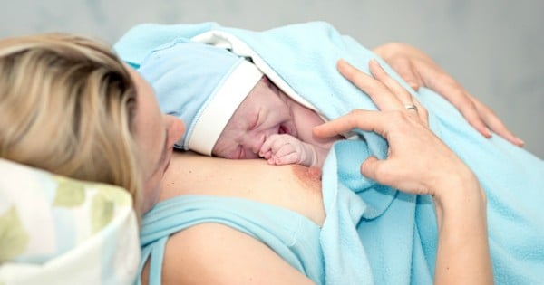 Young beautiful woman with a newborn baby after birth