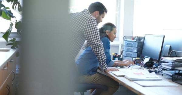 Cropped shot of a handsome young man assisting a female colleague with something on her computer