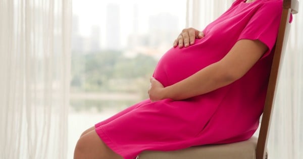 Cropped image of pregnant woman relaxing at home, side view