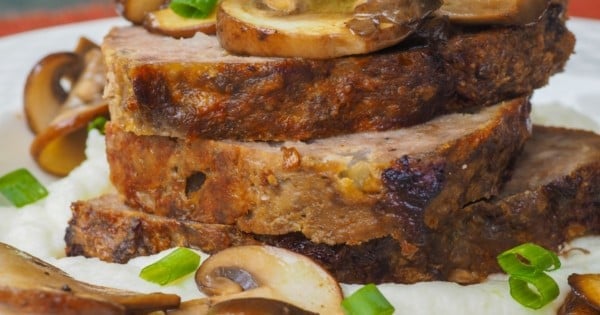 Stack of homemade meatloaf with sauteed mushrooms on Cauliflower mashed "potatoes.