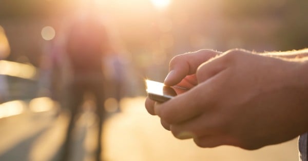 Man using his Mobile Phone outdoor, close up