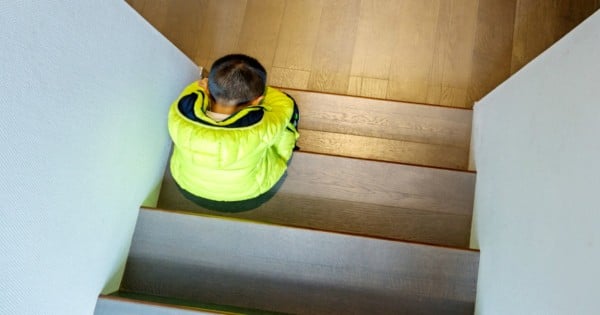 Little boy sitting on a staircase, looks lonely.