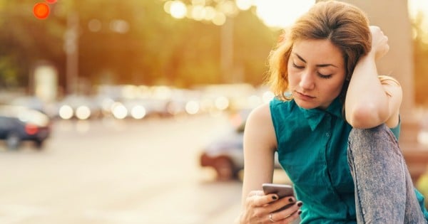 woman looking sad on phone via istock