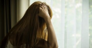 Sad girl looking out of window,social problem.