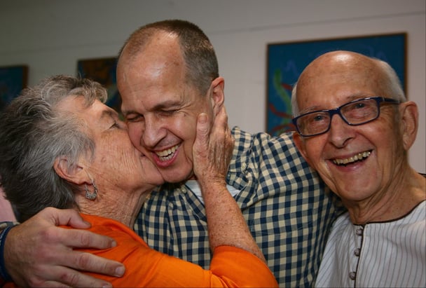 Peter Greste is kissed by his mother Lois (L) and father Juris (R) upon his arrival at Brisbane's international airport in the early hours of February 5, 2015. (Photo: PATRICK HAMILTON/AFP/Getty Images)