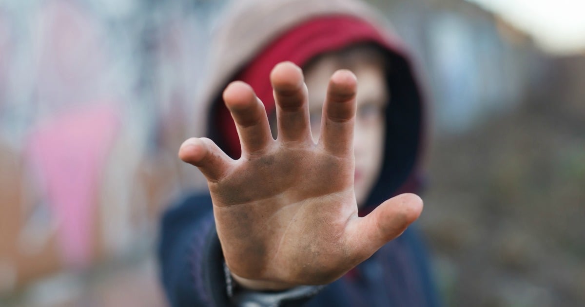 dramatic portrait of a little homeless boy, dirty hand, poverty, city, street