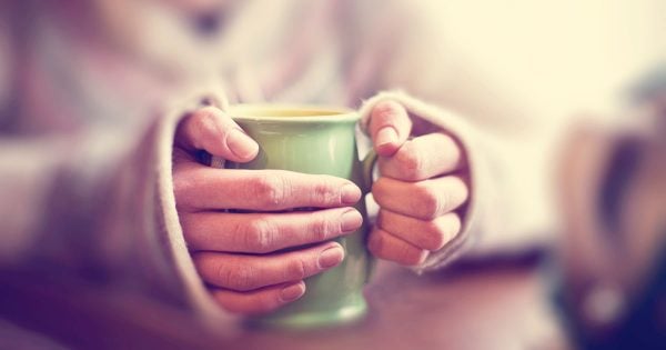 older woman holding mug tea coffee