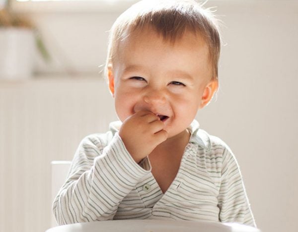 baby eating smiling toddler