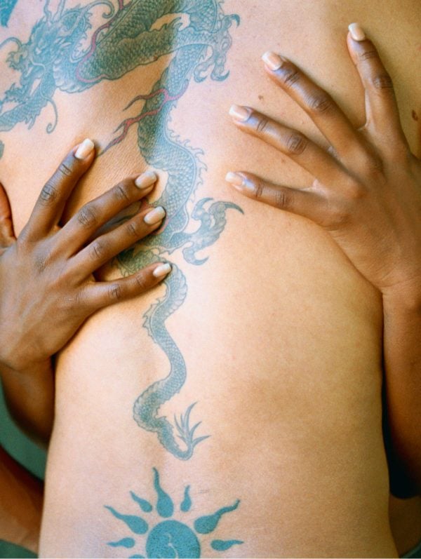 A photo of two people with hands pictured on a back.